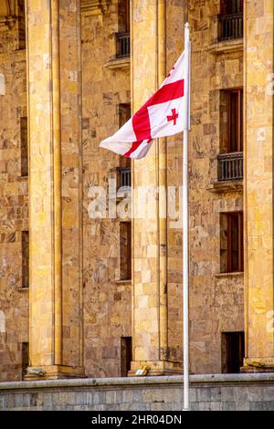 Marble Georgian Parliament Building in Tbilisi Georgia with Georgian flag on tall flagpole - Closeup. Stock Photo