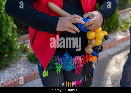 man making funny balloon dog figure for children Stock Photo