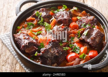 Estofado de Rabo de Toro Spanish Oxtail Stew closeup on a pot on the wooden table. Horizontal Stock Photo