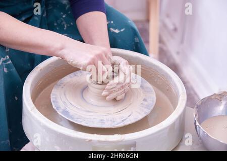hands of a ceramist make dishes on a potter's wheel Stock Photo