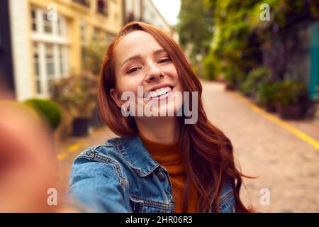 Point Of View Shot Of Young Woman Leading Man Through City Street By The Hand Stock Photo