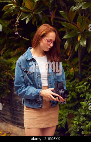Young Woman In City Taking Photo On Retro Medium Format Film Camera To Post To Social Media Stock Photo