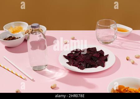 Dried fruits, drink and nuts with sauce on pink table Stock Photo