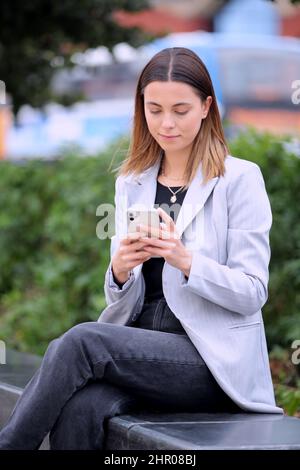 Female Office Worker Outdoors Using Mobile Phone During Break Stock Photo
