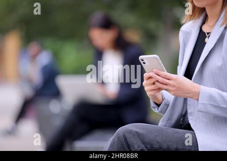 Close Up Of Female Office Worker Outdoors Using Mobile Phone During Break Stock Photo
