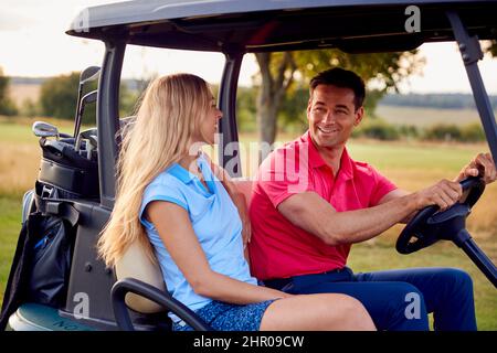 Couple Driving Buggy Playing Round On Golf Together Stock Photo