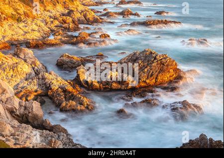 Evening sun light reflect on the rocky shoreline along the California Coast at Big Sur. Stock Photo