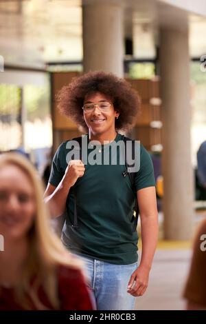 Smiling Male Student In Busy University Or College Building Stock Photo
