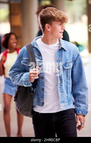 Smiling Male Student In Busy University Or College Building Stock Photo