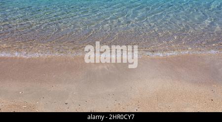 Sandy beach, ocean sea water touch wet sand close up. Greece summer vacation destination Stock Photo