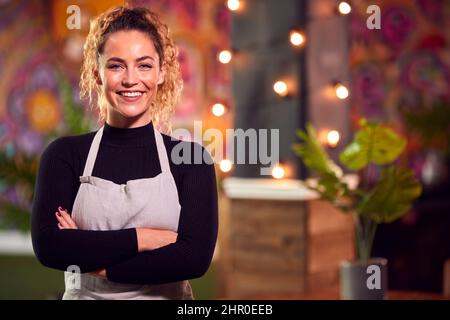 Portrait Of Smiling Female Server Working Night Shift In Bar Restaurant Or Club Stock Photo