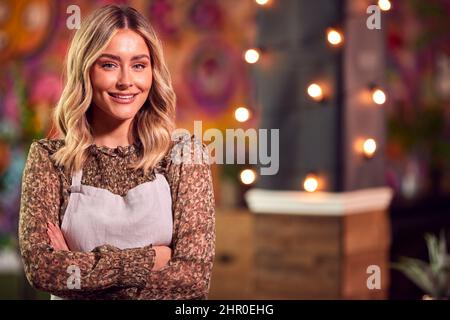 Portrait Of Smiling Female Server Working Night Shift In Bar Restaurant Or Club Stock Photo