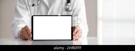 Close-up Of Male Doctor's Hand Holding Digital Tablet With Blank White Screen On White Desk Stock Photo