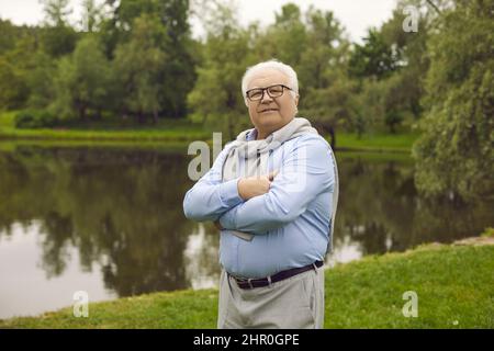 Portrait of a happy senior retired man enjoying retirement walking on a summer day in the park. Stock Photo