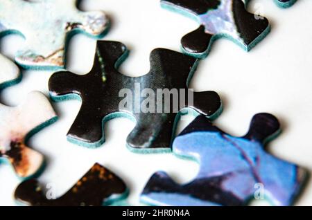 Close up view of jigsaw pieces scattered on a white background. Stock Photo