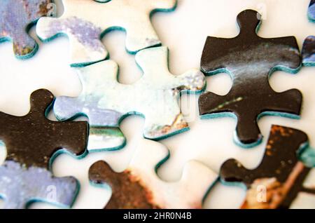 Close up view of jigsaw pieces scattered on a white background. Stock Photo