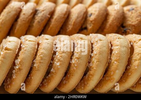 Crispy shortbread sugar biscuits macro background. Row of tasty butter cookies with sugar close-up. Texture of baked pastry for breakfast. Sweet food. Stock Photo