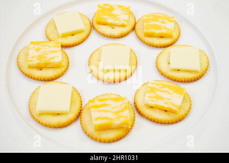 Round Salty Crackers with Sliced Cheese on Top Stock Photo