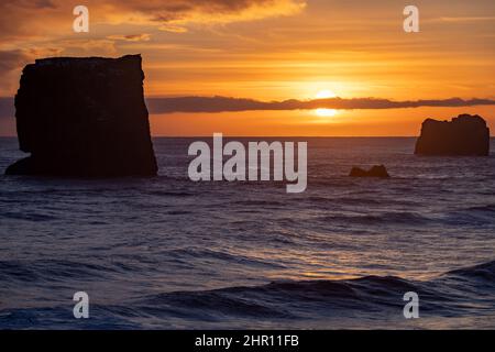 view of rocks and stormy sea at sunset from Dyrholaey Peninsula, southeast Iceland Stock Photo
