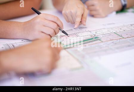 Making sure everything is correct. Cropped shot of a group of architects reviewing blueprints. Stock Photo