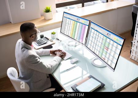 Computer Spreadsheet Data Analyst Man Using Multiple Screens Stock Photo