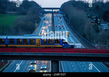 The A3 motorway, evening rush hour traffic on 6 lanes, local train S-Bahn, Regiobahn, S28, crossing the motorway, on the way between Kaarst and Wupper Stock Photo