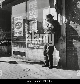 Dorothea Lange - Unemployed, Destitute Man Leaning Against Vacant Store - 'Skid Row.' Howard Street, San Francisco, California, February 1937 Stock Photo