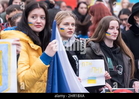 Prague, Czech Republic. 24th Feb, 2022. Women with painted Ukrainian flags on their faces seen during the demonstration. Several thousand demonstrators attended a rally in Prague to show support of Ukraine after Russian president Vladimir Putin authorized military operation in Ukraine. Credit: SOPA Images Limited/Alamy Live News Stock Photo
