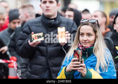 Prague, Czech Republic. 24th Feb, 2022. A protester looks on while holding a smartphone during the demonstration. Several thousand demonstrators attended a rally in Prague to show support of Ukraine after Russian president Vladimir Putin authorized military operation in Ukraine. Credit: SOPA Images Limited/Alamy Live News Stock Photo