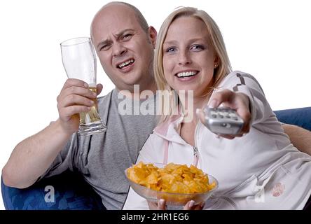 couple enjoys a cozy evening watching TV with a bowl of chips and a glass of beer Stock Photo