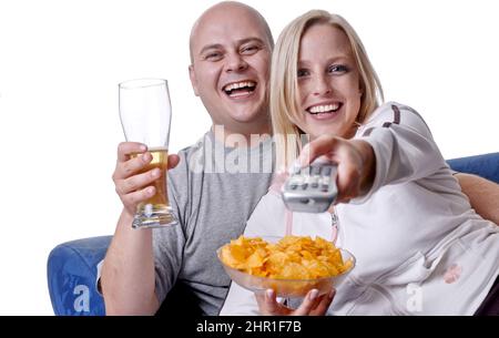 couple enjoys a cozy evening watching TV with a bowl of chips and a glass of beer Stock Photo