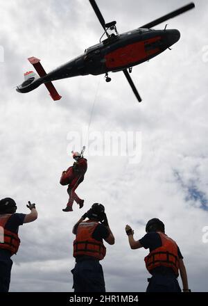 The crew of the Coast Guard Cutter Joseph Gerczak conducted hoist training in Tahiti with the Armed Forces in French Polynesia. The Coast Guard often works with partners in the Pacific to increase interoperability and to deter illegal, unreported, and unregulated fishing. (U.S. Coast Guard photo courtesy of the CGC Joseph Gerczak) Stock Photo