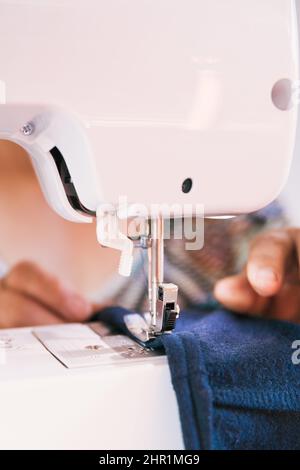 unrecognizable woman using a sewing machine to manufacture clothing. Employment issues Stock Photo