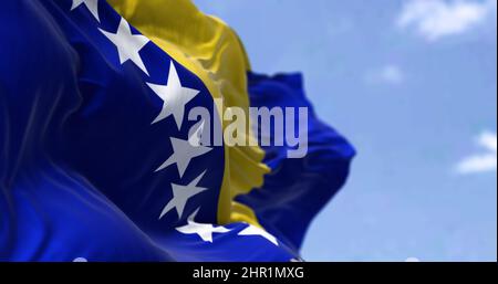 Detail of the national flag of Bosnia and Herzegovina waving in the wind on a clear day. Democracy and politics. Selective focus. Bosnia, is a country Stock Photo