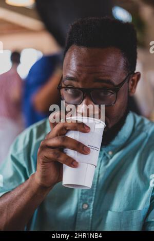 young black man with glasses drinking coffee Stock Photo