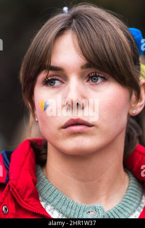 MADRID, SPAIN - FEBRUARY 24: Ukrainian girl attends a demonstration to protest the invasion of Ukraine by Russia with a heart painted on her face in t Stock Photo
