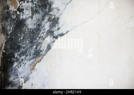 The texture of the concrete wall with partially washed away plaster, water damage and mold. Front view. Stock Photo