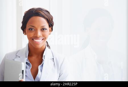 Professional and ambitious. Portrait of a young woman holding a laptop next to her reflection - copyspace. Stock Photo