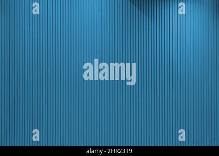 Vertical line textured blue wall with lights hitting it from different angles Stock Photo
