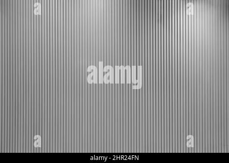 Vertical line textured grey wall with lights hitting it from different angles Stock Photo