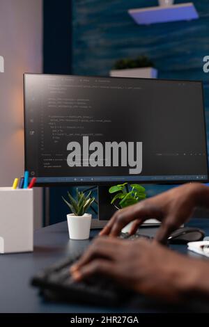 Closeup of programmer man hand typing website script on computer working remote from home. African american hacker worker programming binary code using network security system. Concept of coding Stock Photo