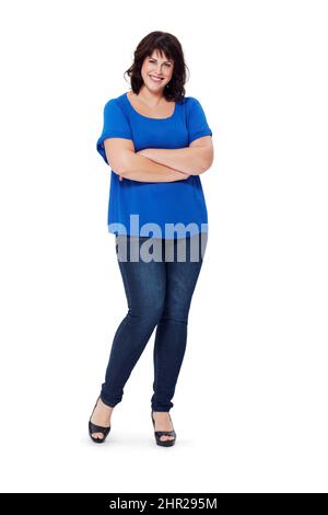 She wears her clothes with attitude. Full length studio shot of a young woman isolated on white. Stock Photo