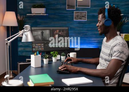 Filmmaker editor sitting at desk table in creativity studio working remote from home at film montage using post production software. Video maker editing movie footage creating content for agency Stock Photo