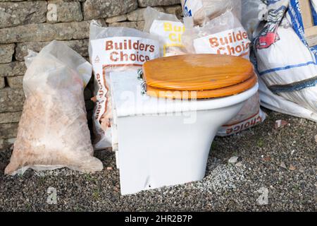 Bathroom Renovation Old toilet and rubble bags Stock Photo