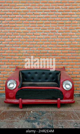A red car sofa with black faux upholstery, on isolated background with clipping path Stock Photo
