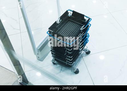 Empty shopping carts or backets on boutique floor. Selective focus. Top view. Stock Photo