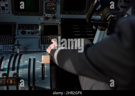 Airline pilot using instrument panel in aircraft cockpit Stock Photo