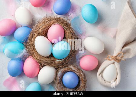 Festive background with Easter eggs and a rabbit on a gray background. Top view. Happy Easter. Stock Photo