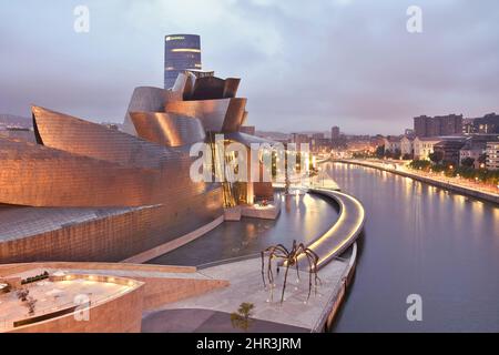 Guggenheim Museum of Modern Art, landmark architecture on the bank of river Nervion at dusk in Bilbao Spain. Designed by Frank Gehry architect. Stock Photo
