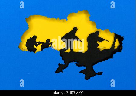 War in Ukraine, illustration photo, Ukraine colors blue and yellow. Silhouette of Ukraine map, black tanks in the background. Conflict between Russia Stock Photo